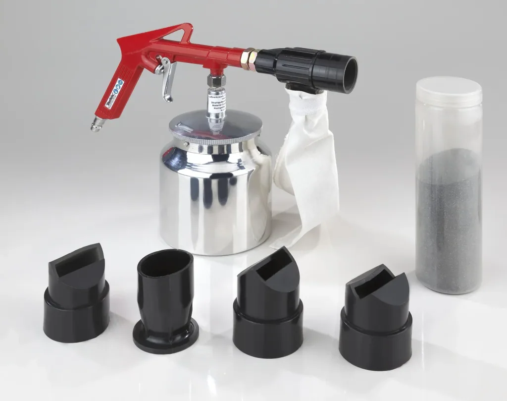 Compressed air sandblasting gun including accessory set