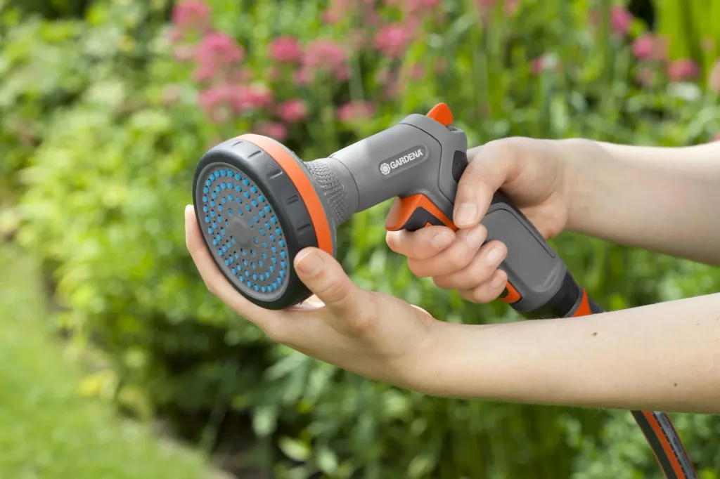 Comfort shower for flowerbeds, impulse trigger with locking function